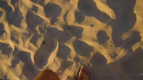 Slow-motion-shot-of-a-man's-feet-walking-through-the-sand-at-Canon-Beach