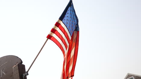 Slow-motion-shot-of-an-American-flag-flying-in-the-wind-off-of-a-flag-pole