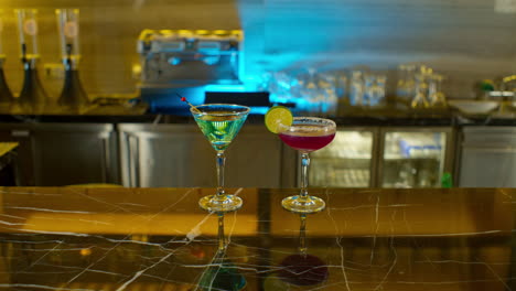 Hand-of-man-leaving-his-drink-on-bar-counter-next-to-his-partner's