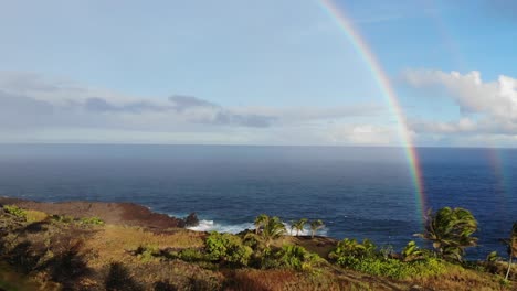 Rising-up-in-front-of-two-rainbows-over-the-pacific-ocean
