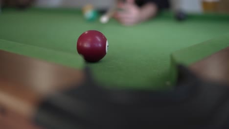 A-woman-playing-pool,-making-a-mistake-and-inadvertently-pocketing-the-cue-ball