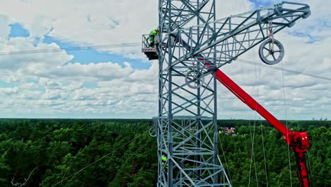 Aerial-panning-shot-of-a-power-pole-while-electricians-are-performing-dangerous-maintenance-work-to-get-the-electricity-flowing-again-and-supply-the-city-with-energy