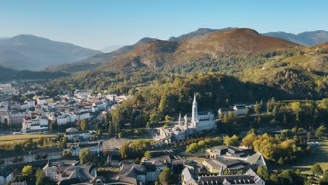 Aufschlussreiche-Luftaufnahme-Der-Kathedrale-Von-Lourdes-Und-Des-Stadtbildes-Im-Sommer