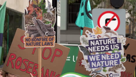 Bei-Einem-Protest-Vor-Dem-Ministerium-Für-Umwelt,-Ernährung-Und-Ländliche-Angelegenheiten-Werden-Zwei-Plakate-Mit-Der-Aufschrift-„Kein-Lagerfeuer-Der-Naturgesetze“-Und-„Die-Natur-Braucht-Uns,-Wir-Brauchen-Die-Natur“-Hochgehalten