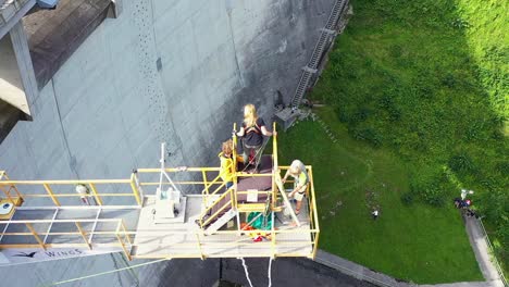 Staff-setting-up-excited-woman-on-Dam-bungee-jumping-Platform-in-Austria