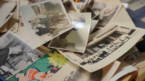 Old-vintage,-black-and-white-photos-concept-pile-of-memories,-handheld