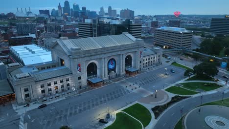 Aerial-drone-shot-of-the-historic-Union-Station-in-Kansas-City,-Missouri,-showcasing-its-grand-architecture-with-the-city-skyline-in-the-backdrop
