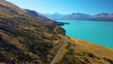 Scenic-aerial-view-along-the-turquoise-waters-of-Lake-Pukaki-with-majestic-Mount-Cook-in-the-distance