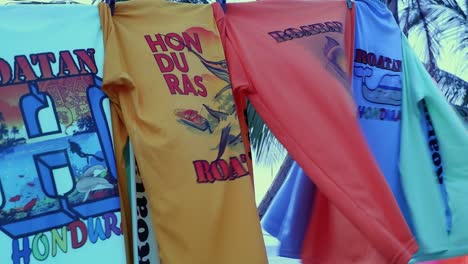 Rash-guard-T-shirts-for-sale-on-clothes-line-in-Roatan,-Honduras
