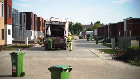 Garbage-haulers-dump-garbage-containers-into-a-truck-in-Kaunas-in-the-daylight