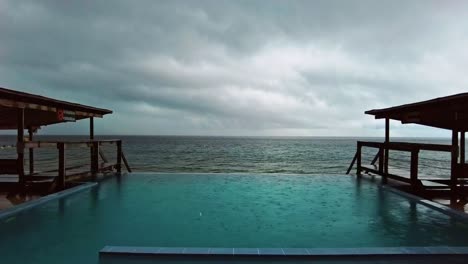 Timelapse-Footage-of-pouring-rain-in-the-swimming-pool-on-the-beach-side