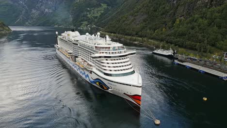 Aerial-of-a-cruise-ship-from-the-AIDA-line-moored-of-the-village-of-Gieranger-at-the-head-of-the-Geirangerfjord,-Norway