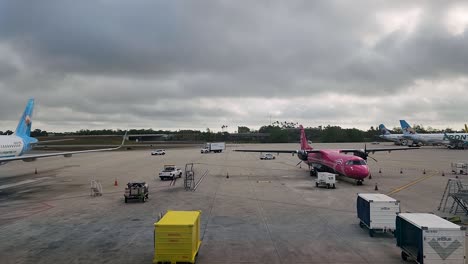 Vehicles-driving-around-in-MCO-airside-1-near-frontier-airlines-and-silver-airways-aircraft-on-a-cloudy-day