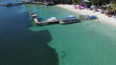Flyover:-Healthy-coral-reefs-in-clear-beach-water-at-West-Bay,-Roatan