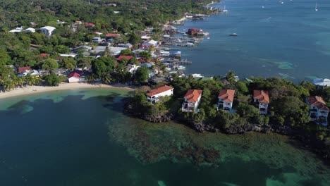 Flyover-waterfront-estate-homes-on-coast-of-Caribbean-Roatan,-Honduras