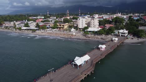 Tourist-pier-flyover-at-mountainous-seaside-city-of-La-Ceiba,-Honduras