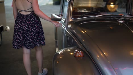 Female-car-model-caressing-a-beautiful-vintage-car-widely-recognized-as-the-German-made-Volkswagen-Beetle-Or-Punch-Buggy