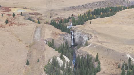 Der-Bighorn-Wasserfall-Fließt-In-Eine-Tiefe-Schlucht-Aus-Erodiertem-Grundgestein-Mit-Scharfen-Klippen-Auf-Beiden-Seiten,-Während-Die-Menschen-Die-Spektakuläre-Aussicht-In-Ya-Ha-Tinda,-Alberta,-Kanada-Genießen
