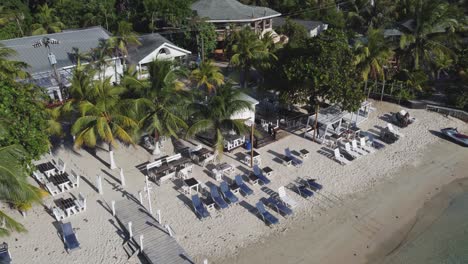 Aerial-view-of-charming-open-air-beach-restaurant,-West-Bay-Roatan