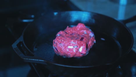 ground-beef-frying-on-the-stove,-in-a-cast-iron-pan,-mean-with-red-onions