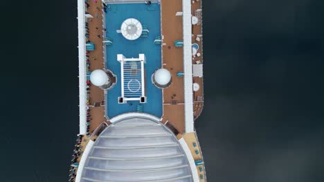 Overhead-aerial-of-a-cruise-ship-from-the-AIDA-line-moored-of-the-village-of-Gieranger-at-the-head-of-the-Geirangerfjord,-Norway