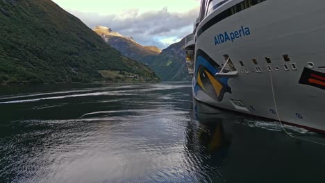 Aérea-De-Un-Crucero-De-La-Línea-Aida-Amarrado-En-El-Pueblo-De-Gieranger-En-La-Cabecera-Del-Fiordo-De-Geiranger,-Noruega