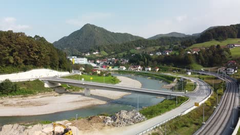 Vista-De-Drones-Del-Río-Entre-Carreteras-En-Marija-Gradec,-Laško-Con-Montañas-Al-Fondo,-Eslovenia