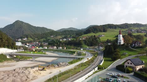 Drone-pan-shot-of-River-and-highways-in-Marija-Gradec,-Laško-with-mountains-in-the-background,-Slovenia