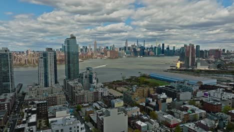 Slow-drone-flight-over-american-neighborhood-in-New-York-City-with-East-River-view-and-skyline-view