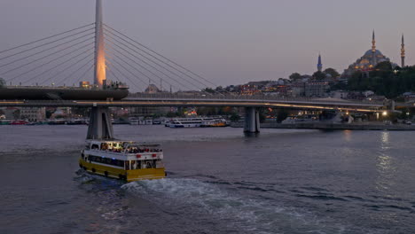 Evening-ferry-cruise-sails-to-illuminated-Golden-Horn-metro-bridge-Istanbul
