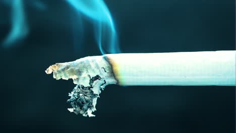 Cigarrillo-Quemado-Liberando-Lentamente-Toxinas-En-El-Aire-Afectando-A-Las-Personas-Alrededor-Con-Enfermedades-Y-Dolencias-Estático-Sin-Movimiento-Humo-Azul-Cenizas-Caen-Del-Cigarrillo-Papel-Blanco-Oscurecido-Por-La-Quemadura-Aterradora