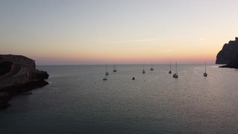 Sonnenaufgang-An-Der-Küste-Mit-Segelbooten-Im-Meer