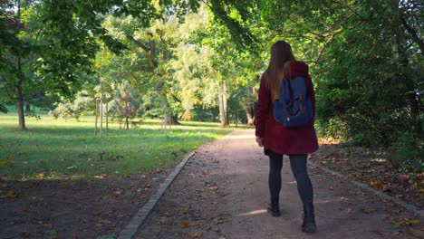 Woman-with-a-backpack-and-long-beautiful-hair-is-walking-along-a-path-in-the-forest