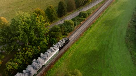 Aerial-view-of-a-steam-train-driving-in-an-autumn-landscape