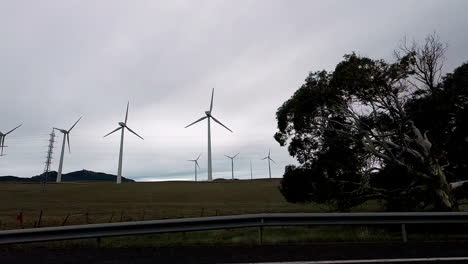 Road-trip-through-a-wind-farm,-a-sustainable-energy-source,-slow-motion
