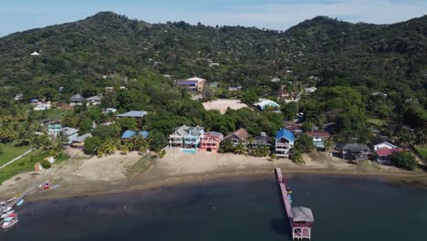 Waterfront-beach-and-buildings-at-Camp-Bay,-Roatan-in-Caribbean-sea