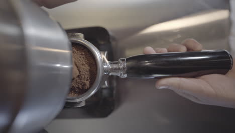 A-Reveal-Shot-Of-A-Coffee-Grinder-processing-Coffee-Beans-And-Collected-In-A-Portafilter