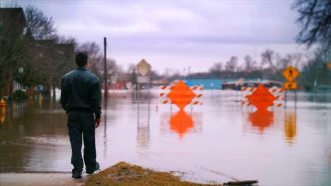 Dramatische-Überschwemmung-Mann-Geht-Straße-Gesperrt-Wasser-Hurrikan-Klimawandel-Hilflose-Autos-Katastrophe-Zerstörung-Überschwemmungshilfe-4k-60fps