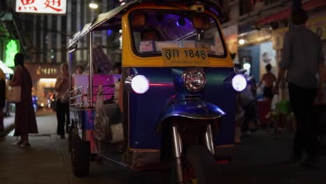 Traditional-Thai-Tuk-Tuk-Taxi-Driving-Through-A-Narrow-Alley-Street-In-Chinatown-Bangkok-