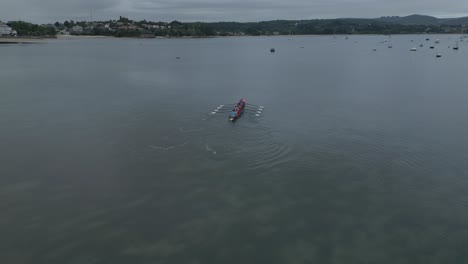 Aerial-tracking-shot-of-Trainera-rowing-team-training-on-coast-of-Ares,-Spain