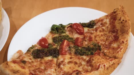 Primer-Plano-De-Deliciosas-Porciones-De-Pizza-Italiana-En-Platos-Blancos-Sobre-La-Mesa-De-Madera-En-Casa,-Deslizándose