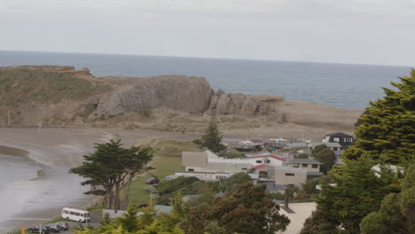 Toma-Panorámica-Sobre-Formación-Rocosa-Y-Faro-En-Castle-Point-Beach-En-Nueva-Zelanda