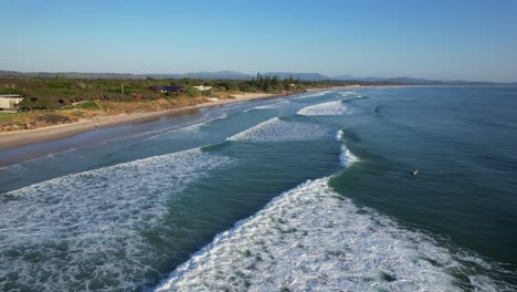 Foamy-Sea-Waves-Splashing-Sandy-Shore-Of-Torakina-Beach-In-New-South-Wales,-Australia---aerial-shot