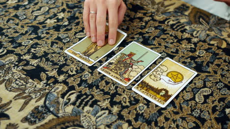 A-woman-giving-a-tarot-reading-with-the-hermit-the-queen-of-swords-and-the-ace-of-pentacles-cards