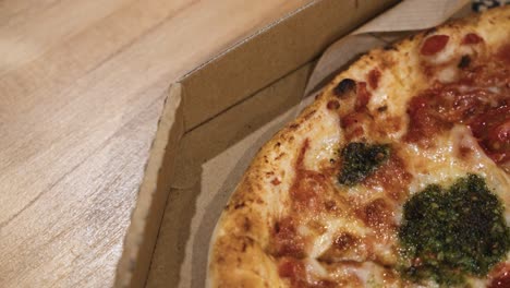 Primer-Plano-De-Deliciosas-Pizzas-Italianas-Entregadas-En-Cajas-Sobre-La-Mesa-De-Madera-En-Casa,-Deslizándose