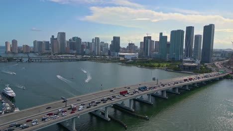 Flyover-traffic-on-MacArthur-Causeway-ICW-Bridge-with-view-towards-Miami-downtown-skyline,-sunny-weather
