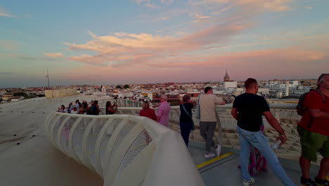 Shot-of-tourists-watching-sunset-in-Las-Setas-de-Sevilla,-also-known-as-Metropol-Parasol,-Seville,-Spain-during-evening-time
