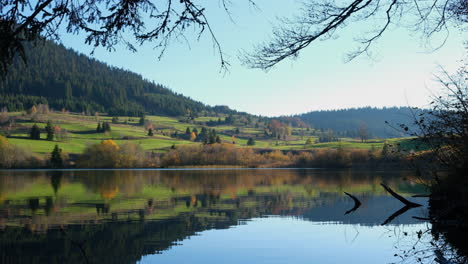 Mountain-lake-in-autumn-day-with-branches-in-foreground