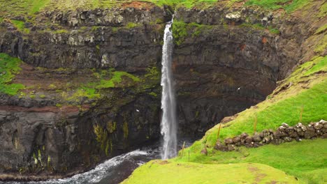 Close-up-shot-of-Mulafossur-waterfall-with-seagulls-flying-around,-Faroe-Islands