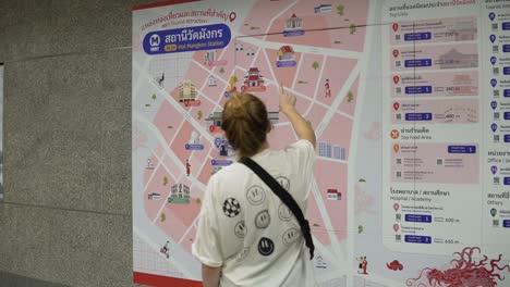 Female-Tourist-In-Bangkok-Thailand-Using-The-MRT-Map-To-Navigate-Her-Travel-Journey